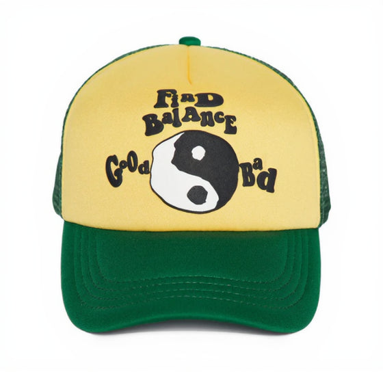 Yellow and green cap with a yin yang symbol and text on a white background