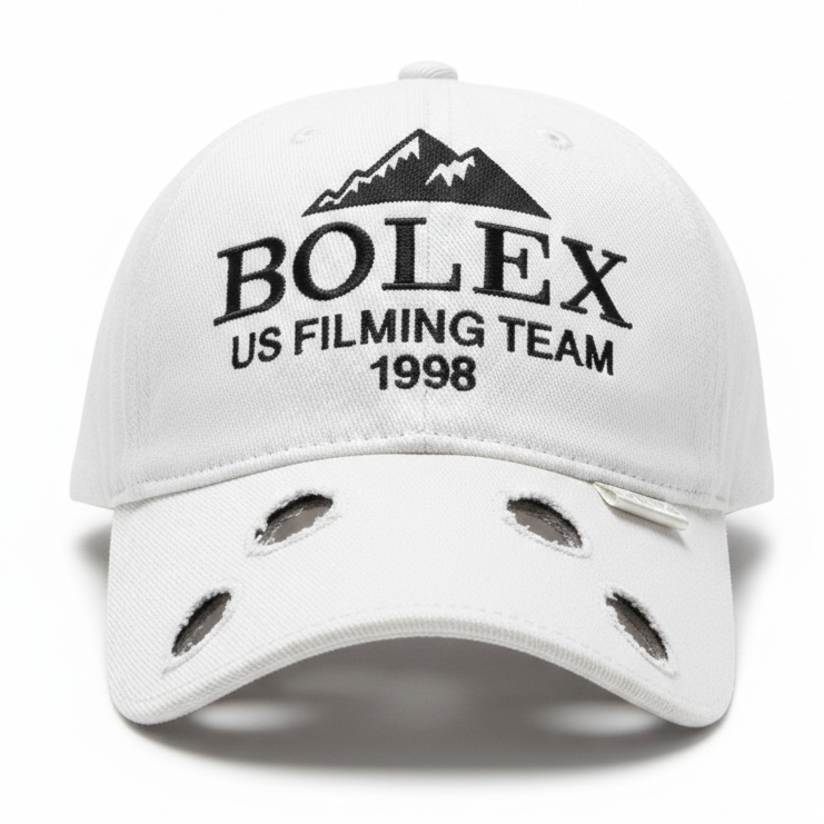 White cap with 'BOLEX US Filming Team 1998' text and mountain design on a white background