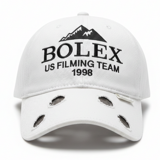 White cap with 'BOLEX US Filming Team 1998' text and mountain design on a white background